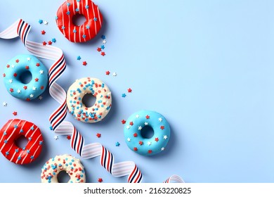 Happy fourth of July, USA Independence Day. 4th of July greeting card template with donuts in colors of American flag and striped ribbon on blue background.