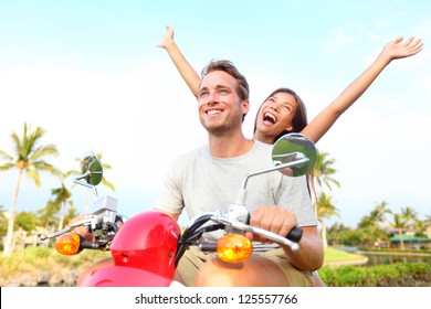 Happy free freedom couple driving scooter excited on summer holidays vacation. Young multiethnic couple, Asian woman, Caucasian man - Powered by Shutterstock