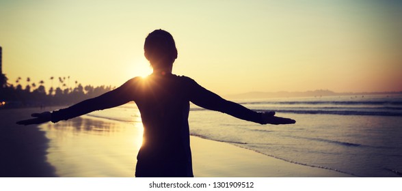 Happy Free Woman at Sunrise on the Beach