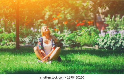 Happy free young woman sitting outdoors in yoga position with closed eyes on summer park grass Calm girl enjoy smile and relax in spring city air. Mindset inner light peace concept.  - Shutterstock ID 1690430230