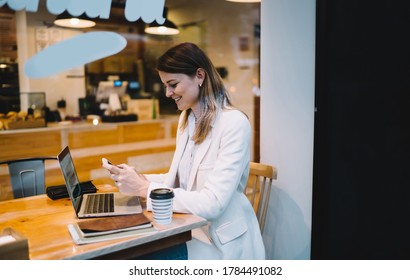 Happy freelancer sharing media files via mobile and laptop technology using bluetooth connection in coffee shop, successful female copywriter publishing network content via smartphone application - Shutterstock ID 1784491082