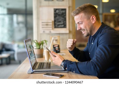 Happy Freelancer With Tablet And Laptop Computer In Coffee Shop. Working Outside The Office.