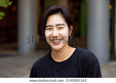 Happy friendly asian non-binary LGBT person smiling to camera