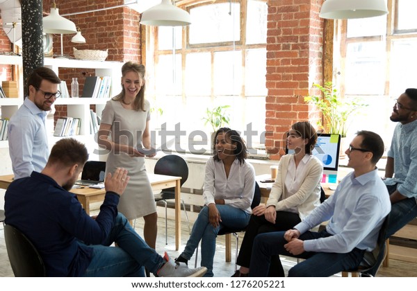 Happy friendly business team having fun at\
corporate training, funny teambuilding activity, diverse employees\
group laughing at briefing, colleagues joking together at meeting,\
staff good relations