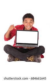 Happy Friendly Teenage Boy Sitting Down And Holding A Laptop, Teenager Wearing Red Shirt And Black Jeans,  Isolated On White Background