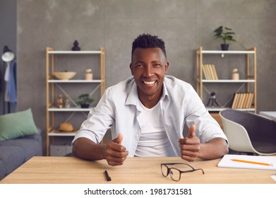 Happy Friendly Young African Man Sitting At Table In Home Office. Web Cam View Of Cheerful Smiling Black Entrepreneur Or College Student. Webinar, Videocall Or Videoconference Laptop Computer Headshot