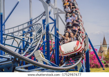 Happy friends in amusement park on a summer day