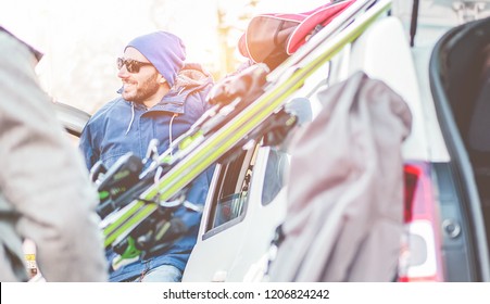 Happy Friends Arrived At Winter Vacation Village With Skies And Snowboards - Young Skiers Having Fun Unloading The Car - Extreme Sport, Holidays And Friendship Concept - Focus On Man With Sunglasses