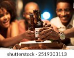 Happy friends, beer and hands toast at office party to celebrate project launch success. Alcohol, drink and African business people cheers for social gathering after deadline at night on Octoberfest