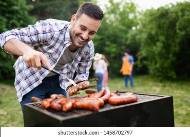 Happy friends camping and having a barbecue in nature