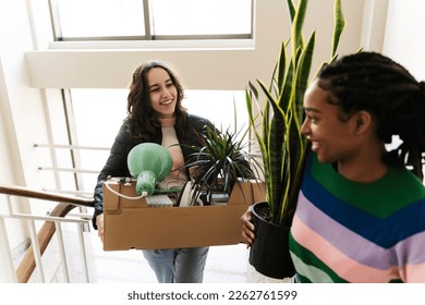 Happy friends carrying boxes on steps Stockfoto