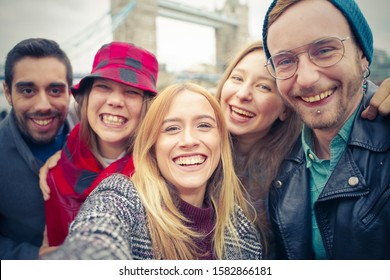 Happy friends caucasian taking selfie. Students having fun with technology trends. Youth, tech and friendship concept - Main focus on the girl. - Shutterstock ID 1582866181