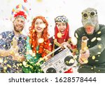 Happy friends celebrating carnival party event outdoor - Young crazy people having fun wearing costumes listening music with vintage boombox stereo - Youth trendy holidays culture lifestyle concept