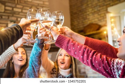 Happy Friends Celebrating Christmas Toasting Champagne Wine At Home Dinner - Winter Holiday Concept With Young People Enjoying Time Together Having Fun At Log Cabin - Warm Filter With Focus On Glasses