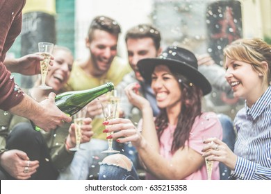 Happy Friends Celebrating Drinking Champagne And Making Party Outdoor - Young Loud People Having Fun Outside - Youth And Fest Concept - Focus On Left Man Hand With Bottle - Warm Contrast Filter