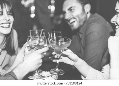 Happy Friends Cheering At Cocktail Bar - Young Trendy People Having Fun Drinking Alcohol And Laughing - Party Concept - Focus On Right Woman Hand Glass - Black And White Editing