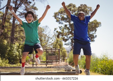 Happy friends cheering on obstacle during obstacle course in boot camp - Powered by Shutterstock