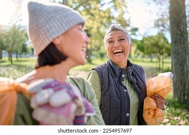 Happy, friends and community cleaning project in park by women for charity, recycling or environment cleanup. Volunteers, senior and young woman bonding while walking in forest volunteering together - Powered by Shutterstock