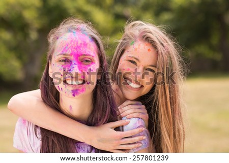 Happy friends covered in powder paint on a sunny day