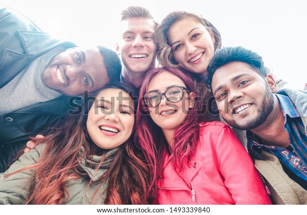 Happy friends from diverse cultures and races taking selfie - Students having fun with technology trends at erasmus university - Youth, tech and friendship concept  - Main focus on bottom girls