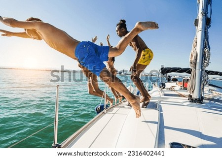 Happy friends diving from sailing boat into the sea - Soft focus on front guy face