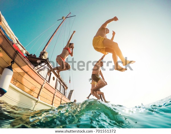 セーリングボートから海に飛び込む幸せな友達 夏の遠足の日に海に飛び込む若者 休暇 若者 楽しいコンセプト の写真素材 今すぐ編集