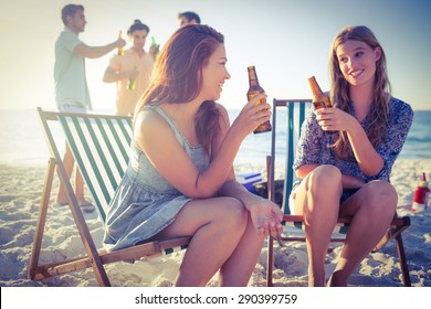 Happy friends doing barbecue and drinking beer at the beach - Powered by Shutterstock