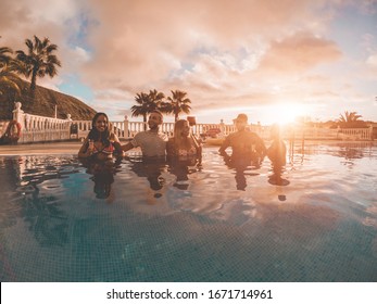 Happy Friends Drinking Champagne In Pool Party At Sunset - Rich People Having Fun In Exclusive Tropical Vacation - Holiday, Youth Lifestyle And Friendship Concept - Main Focus On Left Guys