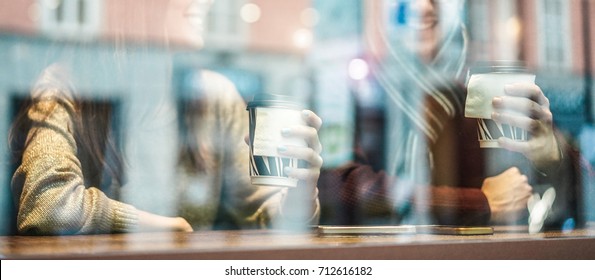 Happy Friends Drinking Coffee In Street City Bar - Young Workers Having Job Break Sitting In Cafe - Reflection View From Outside - Soft Focus On Woman's Paper Cup - Warm Contrast Filter