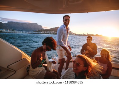 Happy Friends Drinking And Having Fun In Boat Party. Young Rich People Enjoying Sunset Boat Party.