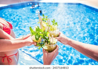 Happy friends drinking mojito cocktails at summer pool party - Young people celebrating summer holidays outdoors - Food and beverage life style concept - Powered by Shutterstock