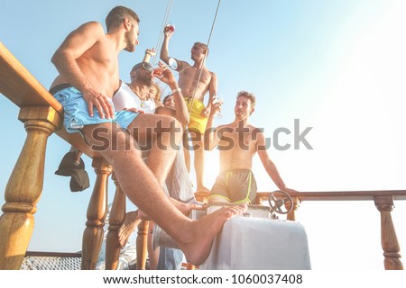 Happy friends drinking sangria in boat exclusive party - Rich young people having fun in summer vacation tour - Main focus on left man - Travel, friendship, holidays and youth concept