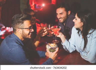 Happy Friends Drinking And Toasting Cocktails In A Jazz Bar - Young People Cheering And Laughing Together In A Club At Night - Friendship, Lifestyle, Nightlife Concept 