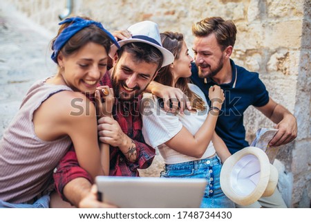 Similar – Young happy people looking tablet over table