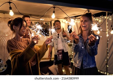 Happy friends enjoying time on camping while holding sparklers - Shutterstock ID 2164380999