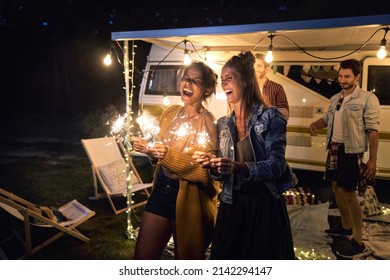 Happy friends enjoying time while holding sparklers - Powered by Shutterstock