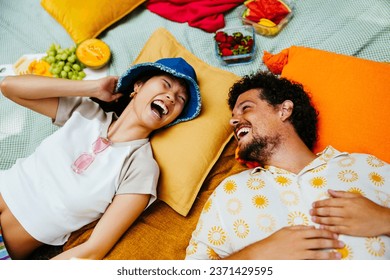 Amigos felices disfrutando juntos y acostados en una manta de picnic Foto de stock