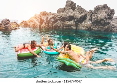 Happy Friends Floating With Lilos, Drinking Beer In Sea Natural Pool - Young Trendy People Having Fun Swimming In Summer Vacation - Youth Lifestyle, Travel And Party Concept - Focus On Tree Left Guys