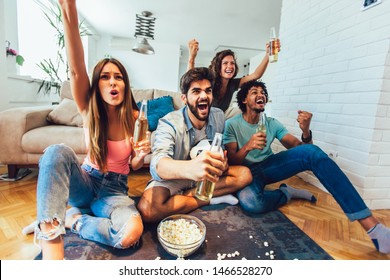 Happy friends or football fans watching soccer on tv and celebrating victory at home.Friendship, sports and entertainment concept. - Powered by Shutterstock