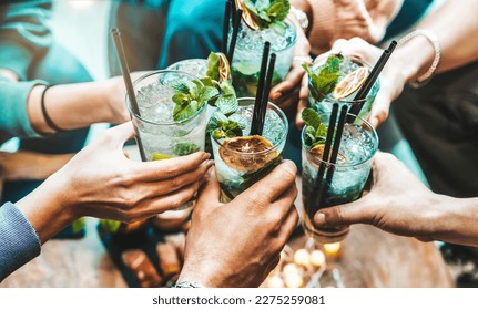 Happy friends group cheering mojito drinks at fancy bar restaurant - Young people having fun toasting cocktail glasses enjoying happy hour at rooftop pub - Party time, life style and youth concept - Shutterstock ID 2275259081