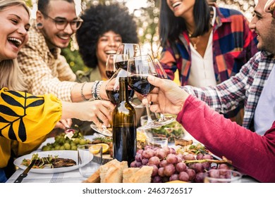 Happy friends having bbq dinner party in restaurant garden - Group of young people drinking red wine and eating meat sitting at lunch table - Food and beverage lifestyle concept - Powered by Shutterstock
