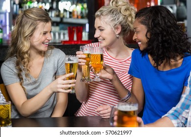 Happy friends having a drink in a bar