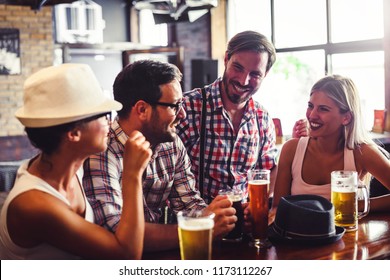 Happy Friends Having Fun At Bar - Young Trendy People Drinking Beer And Laughing Together