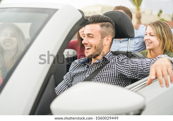Happy\
friends having fun in convertible car on summer vacation - Young\
people laughing and smiling during summer vacation - Focus on man\
face - Travel, rich lifestyle and youth\
concept