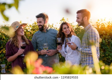 Happy Friends Having Fun Drinking Wine At Winery Vineyard - Friendship Concept With Young People Enjoying Harvest Time Together