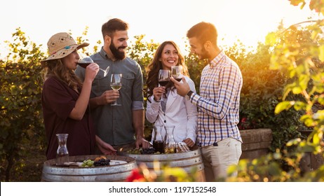 Happy friends having fun drinking wine at winery vineyard - Friendship concept with young people enjoying harvest time together - Powered by Shutterstock