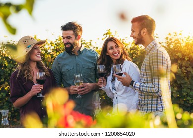 Happy Friends Having Fun Drinking Wine At Winery Vineyard - Friendship Concept With Young People Enjoying Harvest Time Together