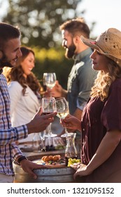 Happy Friends Having Fun Drinking Wine At Winery Vineyard - Friendship Concept With Young People Enjoying Harvest Time Together