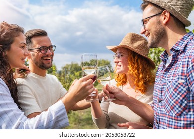 Happy Friends Having Fun Drinking Wine At Winery Vineyard - Friendship Concept With Young People Enjoying Harvest Time Together