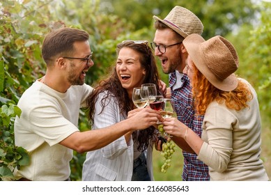 Happy friends having fun drinking wine at winery vineyard - Friendship concept with young people enjoying harvest time together - Powered by Shutterstock